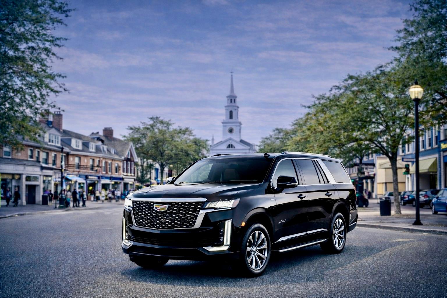 Black sedan airport car service driving to Boston Logan Airport at dusk